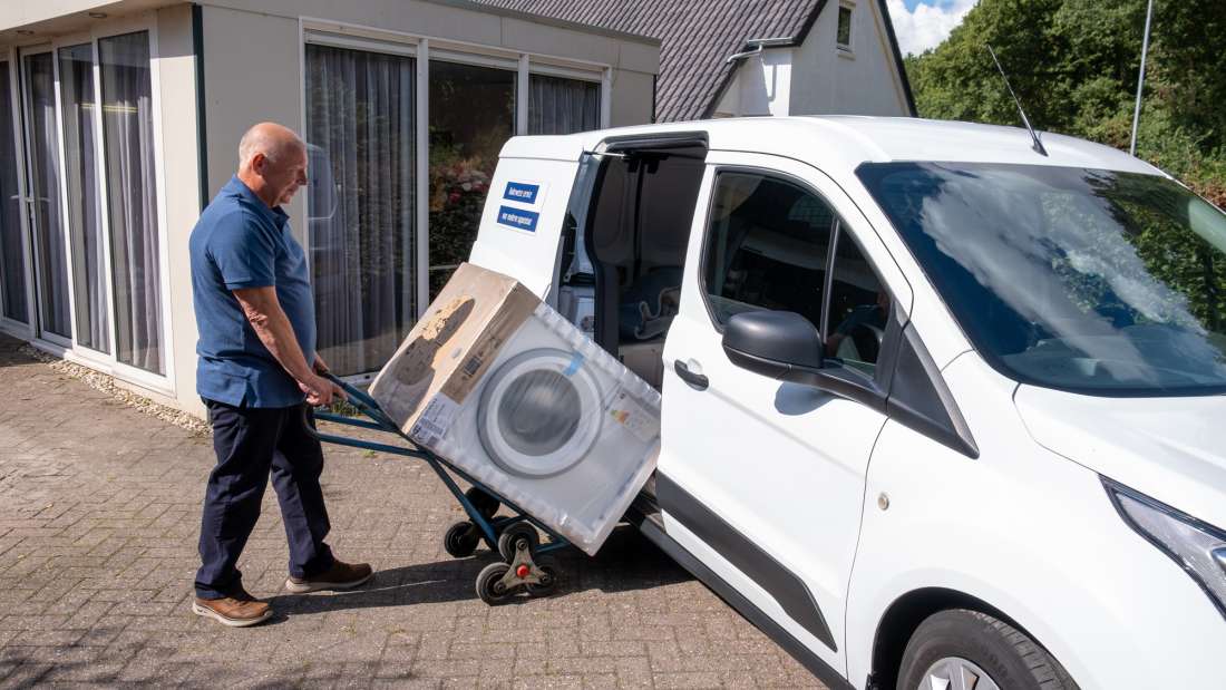 Bert laadt een wasmachine in de Ruvo auto in Emmen